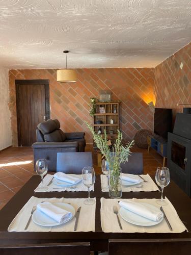 ein Esszimmer mit einem Tisch mit Tellern und Weingläsern in der Unterkunft HOTEL ENOTURISMO MAINETES in Fuente-Álamo