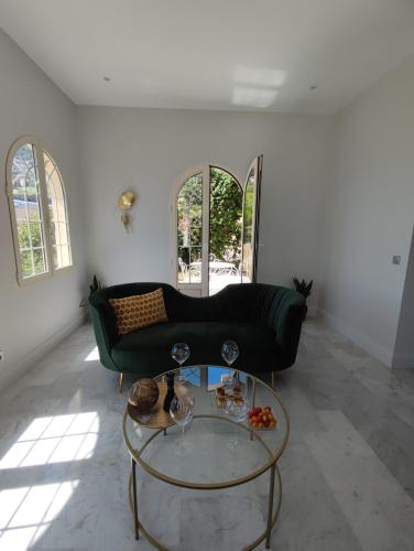 - un salon avec un canapé noir et une table en verre dans l'établissement MAISON AVEC SPLENDIDE VUE MER et MONACO 5 minutes des PLAGES, à Roquebrune-Cap-Martin