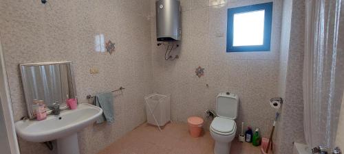 a bathroom with a sink and a toilet and a window at Sea Pearl in Ras Sedr