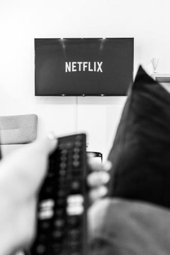 a person holding a remote control in front of a tv at Thome Bucegi Studio in Cluj-Napoca