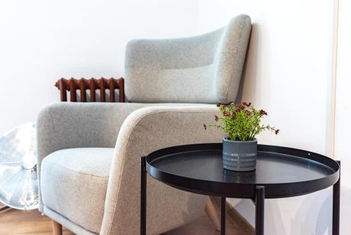 a living room with a chair and a table at Thome Bucegi Studio in Cluj-Napoca
