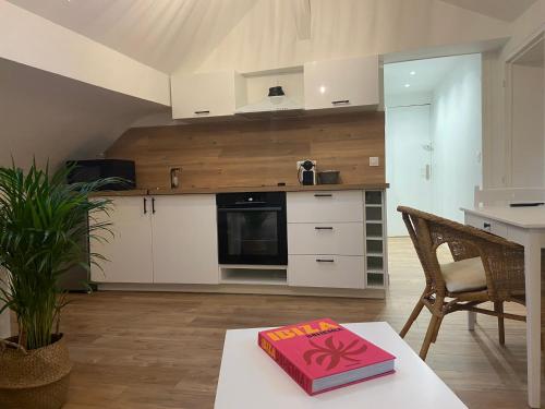 un livre rouge assis sur une table dans une cuisine dans l'établissement La Mansarde LCD Pontoise, à Pontoise