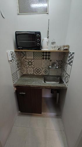 um balcão de cozinha com um lavatório e um micro-ondas em Moderno departamento en inmejorable ubicación con estacionamiento opcional em Mendoza