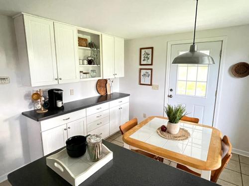Penfield的住宿－Cozy Cottage Convenience，一间带桌子的厨房和一间餐厅