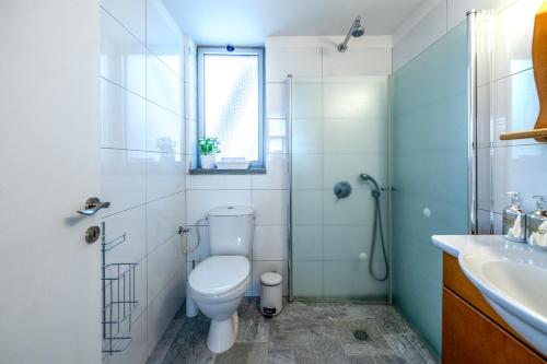 a bathroom with a toilet and a shower and a sink at יער האלונים in Ein Zivan