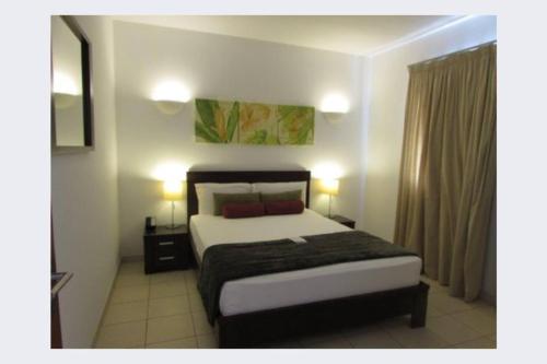 1 dormitorio con 1 cama y 2 luces encendidas en Tortuga beach lovely 2 bed apartment and gardens, en Santa Maria