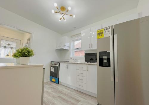 a kitchen with white cabinets and a refrigerator at 2B with parking, 10km to Toronto downtown in Toronto