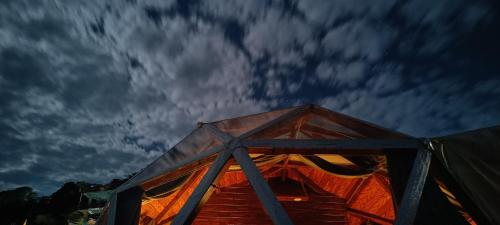 a tent under a cloudy sky at night at Starlit Dome Mcleodganj in Dharamshala