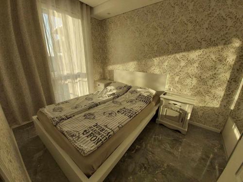 a bedroom with a bed and a table with a window at Gilužio Rivjera in Vilnius