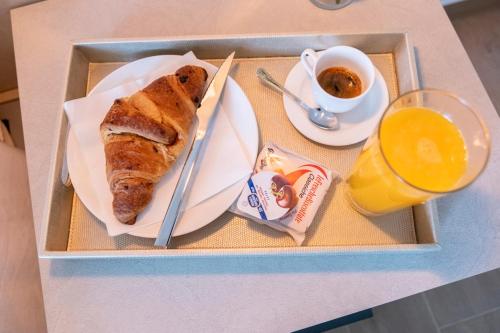a tray with a plate of food and a cup of orange juice at B&B La Caruscia in Trivento