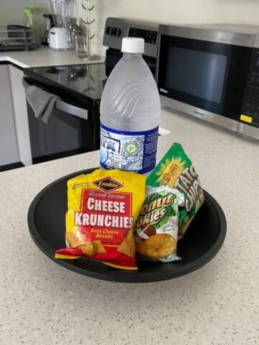 a plate of food with a bottle of water and snacks at Lovely 2 BedRoom c̅ Netflix across National Stadium Kingston in Kingston