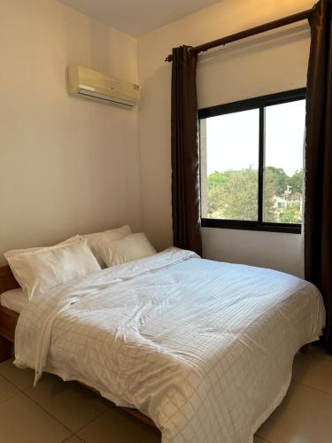 een slaapkamer met een groot bed en een raam bij The Perfect Cozy Home For You in Dar es Salaam