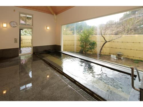 ein leeres Zimmer mit einem großen Fenster und einem Pool mit Wasser in der Unterkunft Misato no Yu Kajikaso - Vacation STAY 22199v in Kimino