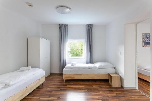 a bedroom with two beds and a window at T&K Apartments - Duisburg - 3 and 4 Room Monteur Apartments in Duisburg