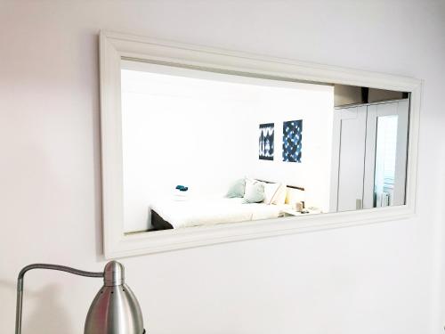 a mirror on a wall with a bed in a room at VICTORIEI STUDIO - PARC KISELEFF in Bucharest