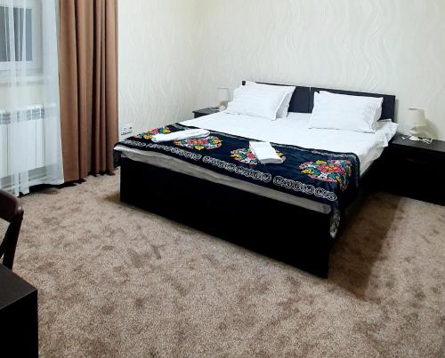 a bedroom with a large bed with a black headboard at Ocean hotel in Osh