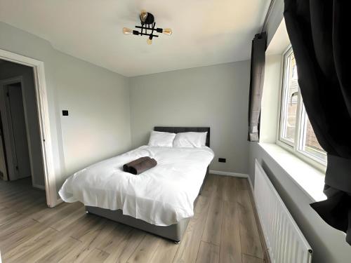 a bedroom with a bed with white sheets and white pillows at New Stylish 2 Bedroom House in Kent
