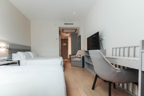 a hotel room with two beds and a chair at Elements Hotel & Shops Curaçao in Willemstad