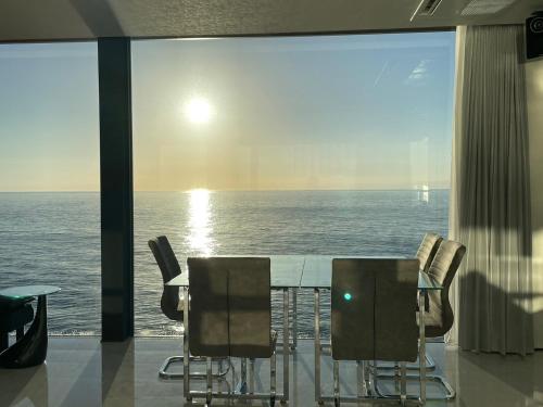 洲本市にあるNamioto Terrace Suite Villa in AIGA - Vacation STAY 30551vのテーブルと椅子が備わる客室で、海の景色を望めます。