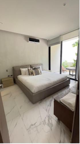 a bedroom with a large bed and a large window at Unlock Your Dream Getaway-Escape in Tulum