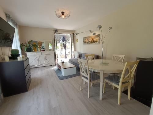 a dining room with a table and a kitchen at Maison entière 65 m² 5 personnes + jardin au calme in Saint-Aulaire