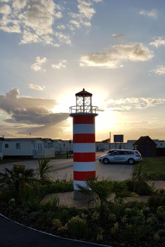 a car parked next to a red and white lighthouse at Memories Made in Selsey
