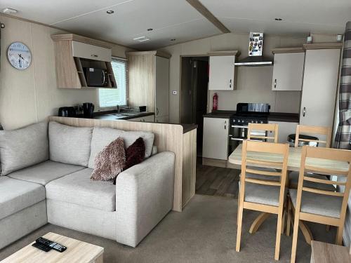 a living room and kitchen with a couch and a table at Memories Made in Selsey