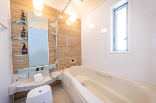 a bathroom with a tub and a toilet and a sink at HOTEL Flag Tokyo - Vacation STAY 29759v in Tokyo