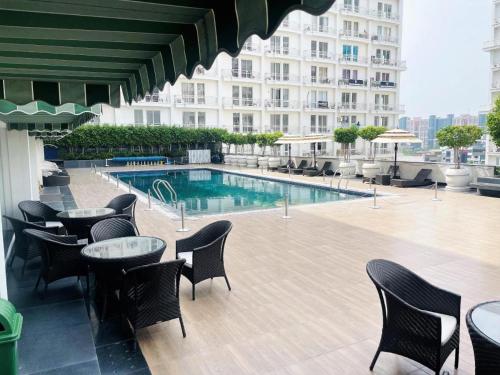 a hotel patio with tables and chairs and a swimming pool at Golden Penthouse - Couple Friendly - DLF My pad, Gomtinagar, Lucknow in Lucknow