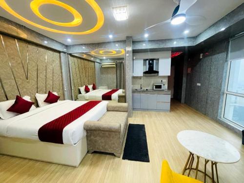 Golden Penthouse - Couple Friendly - DLF My pad, Gomtinagar, Lucknow في لاكناو: غرفة نوم بسرير وطاولة ومطبخ