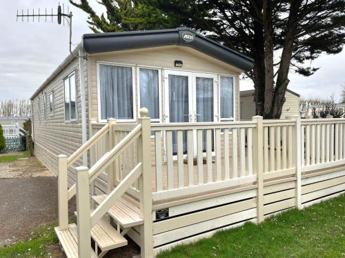 a tiny house with a white fence at Memories Made in Selsey