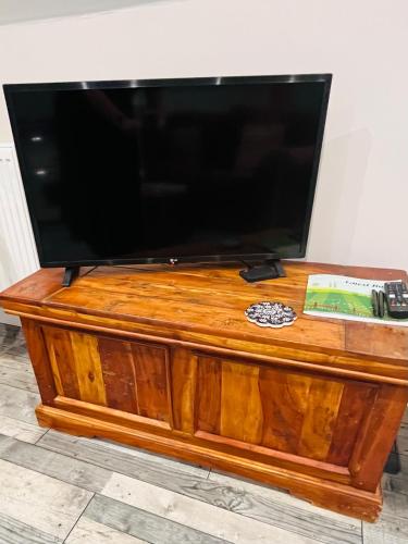 a flat screen tv sitting on top of a wooden dresser at The Honeysuckle Coop in Grantham