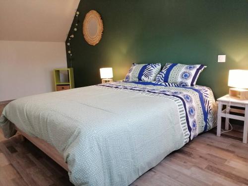 een slaapkamer met een groot bed en een groene muur bij gite a la campagne in Saint-Aubin-de-Terregatte