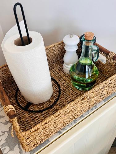 a wicker basket with a vase and other items on a table at The Honeysuckle Coop in Grantham