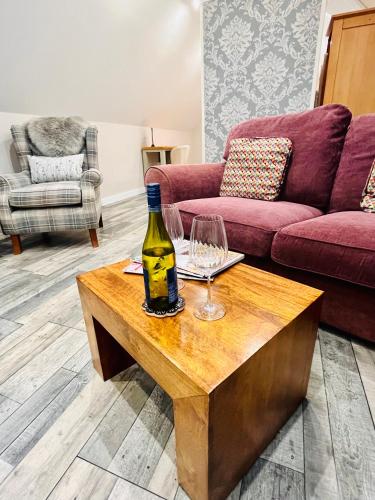 a bottle of wine and a wine glass on a table at The Honeysuckle Coop in Grantham