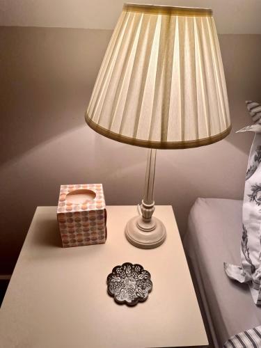 a table with a lamp and a basket on it at The Honeysuckle Coop in Grantham