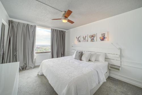 Downtown Tulsa Apartment - Near BOK Center! في تولسا: غرفة نوم بيضاء بها سرير ونافذة