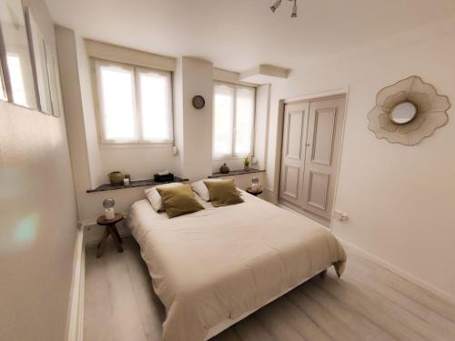 a white bedroom with a large bed and a window at Sublime appartement hyper centre Hirson in Hirson