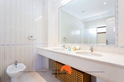 a bathroom with a sink and a toilet and a mirror at #185 V3 Laranjeiras by Home Holidays in Albufeira