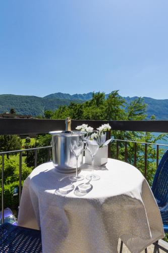 a table with wine glasses and a bucket on a balcony at Hotel Riviera in Melide
