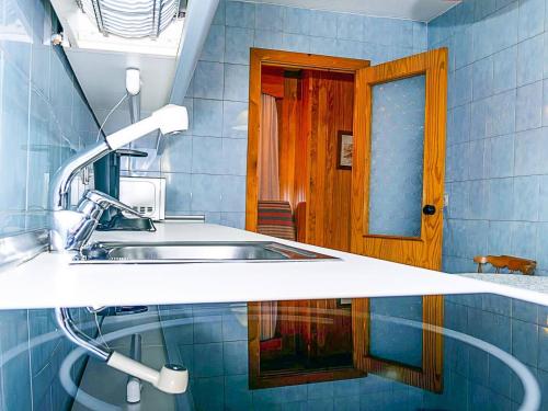 a bathroom with a sink and a wooden door at Apartamento Deluxe zona Baja con Garaje in Sierra Nevada