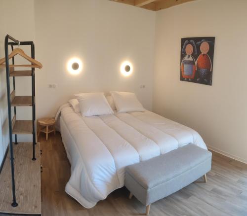 Un dormitorio con una gran cama blanca y una escalera en Alsace Chalet & Spa Meyer-Krumb, en Sigolsheim