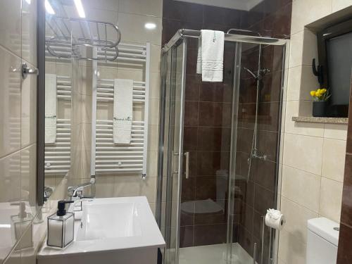 W łazience znajduje się umywalka i przeszklony prysznic. w obiekcie Quinta do Sonho w mieście Resende