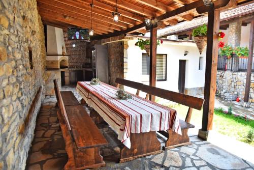 a wooden bench on a patio with a table at GERANA HOUSE in Kilifarevo