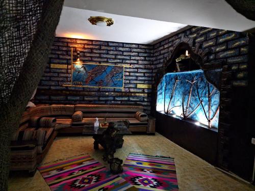 sala de estar con pared de ladrillo y sofá en Petra Anas House, en Wadi Musa