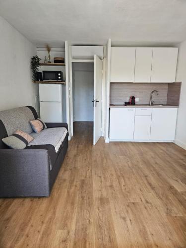 a living room with a couch and a kitchen at Studio Le Santa-Maria - Frejus Plage in Fréjus