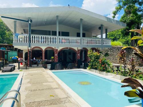 a house with a swimming pool in front of a house at LA CASONA SV in La Libertad