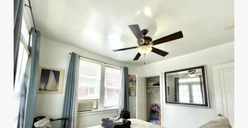 a living room with a ceiling fan and a mirror at (55.1S) Experience a True STL Visit! in Saint Louis