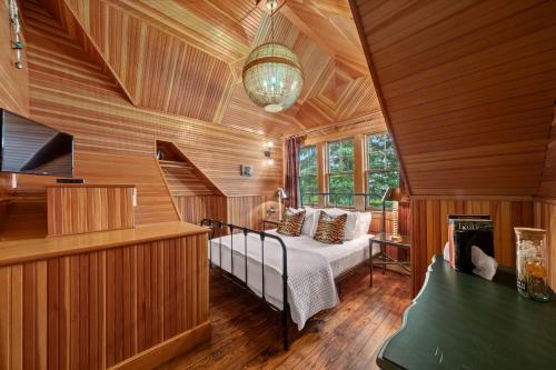 a bedroom with a bed in a room with wooden walls at Hotel Mountain Brook in Tannersville