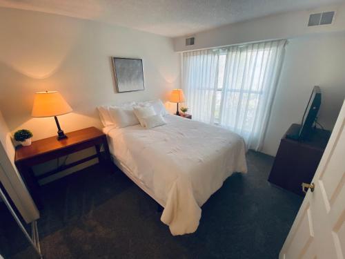 - une chambre avec un lit, deux lampes et une télévision dans l'établissement The Holistic Escape w/Fast WiFi & Free Parking, à Houston